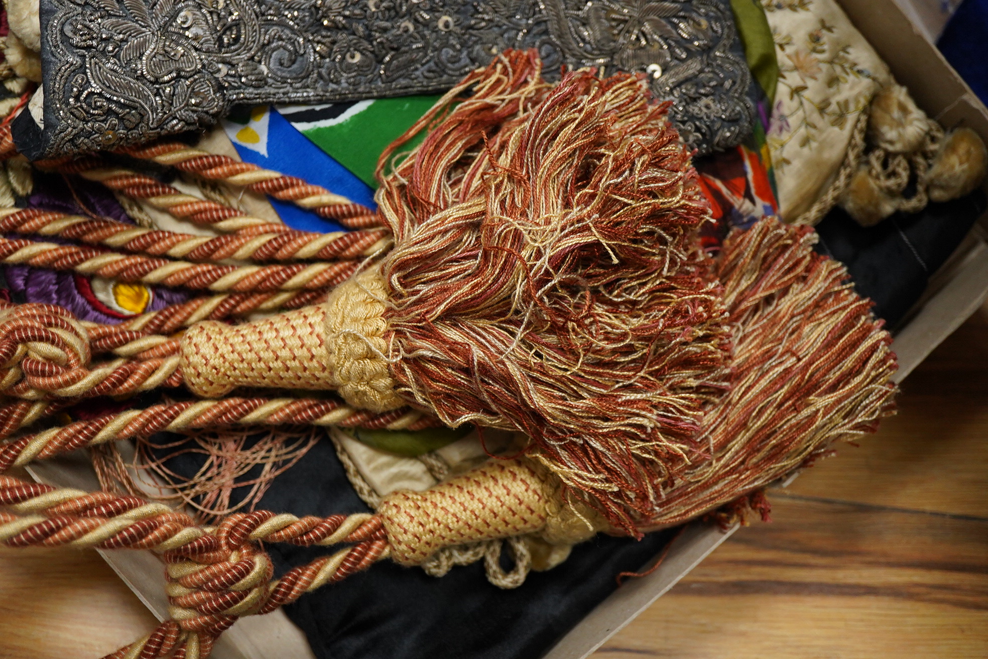 A collection of textiles: a ribbon work hankie and pyjama case, a metalwork collar, a coloured printed shawl, a nurses belt and embroidered belt, an advertising Guggenheim Bilbau hankie etc (10). Hankie case 22cm square.